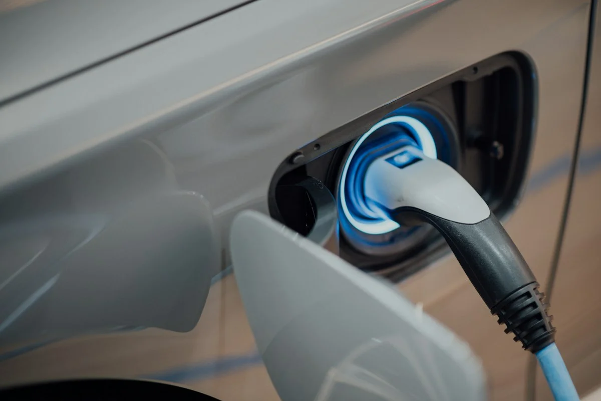 Electric vehicle plugged into sleek Level 2 home wallbox charger inside residential garage